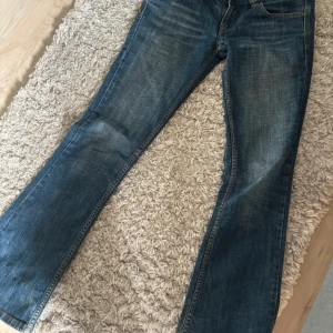 Blå bootcut jeans med broderade bakfickor - Snygga blå jeans från Disel med bootcut passform och broderade detaljer på bakfickorna. Klassisk femficksmodell med låg midja 