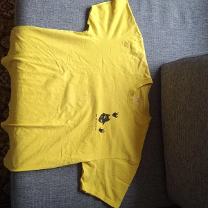 Gul polar skate t-shirt - Säljer en cool gul t-shirt med unikt svart tryck både fram och bak. Perfekt för dig som vill sticka ut med en färgglad stil. T-shirten har korta ärmar och är gjord i ett mjukt material.