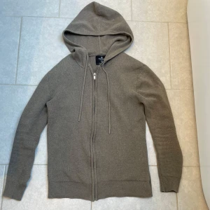 Beige hoodie från Springfield - Säljer en stilren grå stickad hoodie från Springfield i storlek XS