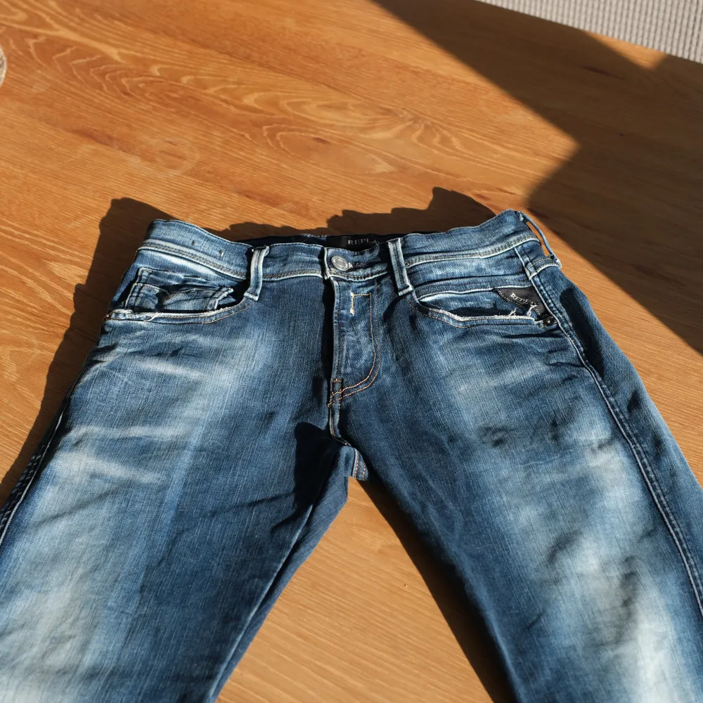 Snygga blå jeans från Replay med en klassisk femficksdesign och lätt slitna detaljer. De har en knappgylf och är perfekta för en avslappnad stil. Märkesloggan syns på bakfickan. Endast använda 1-2 gånger.. Farkut & Housut.