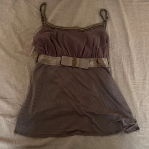 linne med rosett - ett brunt/olivgrönt linne med spets och rosett detalj! köpte på vinted men passade inte mig så säljer vidare🩷