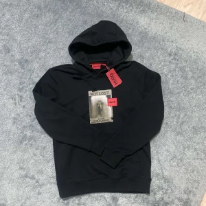 Hugo Hoodie - Snygg svart hoodie från Hugo med tryck på framsidan. Den sitter väldigt bekvämt, och passar perfekt till nuvarande väder. Hoodien är både för män och kvinnor. Den har aldrig används och etiketterna är fortfarande kvar! Priset är inte hugget i sten, går att diskutera för snabbaffär!