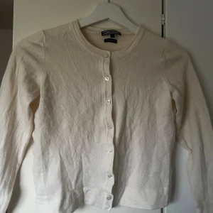 Beige kofta från Tommy Hilfiger - Säljer en elegant beige kofta från Tommy Hilfiger i lyxig ull. Koftan har långa ärmar och knäpps med knappar framtill. Perfekt för en stilren look. 🧥✨