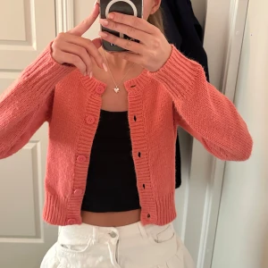 Asball kofta i fin färg - Kofta med knappar! Ceriserosa i fint skick, pyttelite nopprig därav sänkt pris, går lätt att ta bort