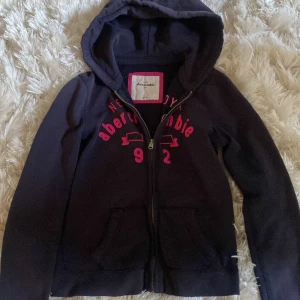  hoodie från Abercrombie - Säljer en snygg mörkblå hoodie från Abercrombie! Använd för väldigt länge sen men syns ej, storleken är under xs 