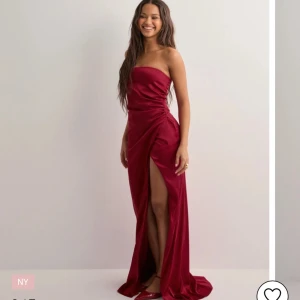 Röd axelbandslös klänning - Säljer denna balklänningen då jag har hittat en annan, aldrig använd. Mått och fler bilder kan skickas!