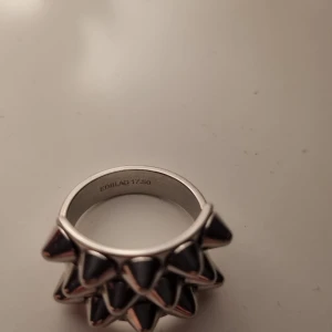 Silvrig ring med nitar från Edblad - Cool och unik ring från Edblad i silver med nitar runt om. Perfekt för att ge din outfit en edgy touch. Storlek 17.50 enligt märkning på insidan.