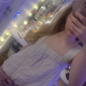 Beige/vit topp från Kay/Day - Säljer en söt vit/beige topp från Kay/Day. Toppen har en luftig passform med breda axelband och en lätt rynkad design vid bysten. Perfekt för varma sommardagar! 🌞