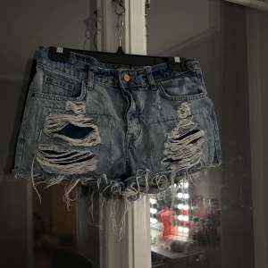 Blå jeansshorts från Perfect Jeans Gina tricot  - Säljer ett par coola blå jeansshorts från Perfect Jeans. De har en snygg slitning framtill och fransiga kanter!💕