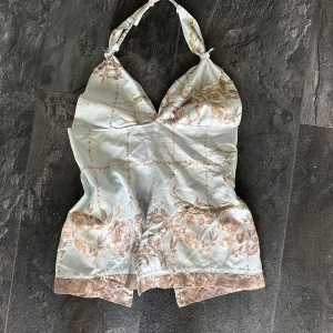 Blommig halterneck linnetopp med paljetter - 🦋Handsydd🦋Supersöt ljusblå halterneck med blommigt mönster. Toppen har knyt i nacken och ryggen, samt paljett-detaljer och en slits framtill. 