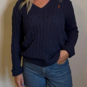 Marinblå Ralph Lauren v ringad kabelstickad tröja dam/tjej - En jättesnygg marinblå Ralph Lauren v-ringad kabelstickad dam tröja | storlek XL på lappen men sitter som S-M | skick 10/10 använd några gånger bara | skriv om du har några frågor!
