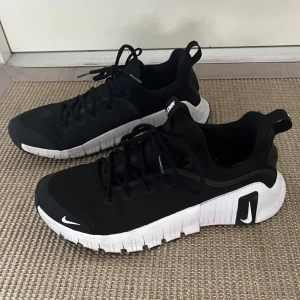 Nike metcon 6 - Snygga svarta Nike sneakers .Ovandelen är i textil och syntet, med rund tå och dragflik bak för enkel påtagning. Köpta för 1750kr, använda inomhus bara ett par gånger! 