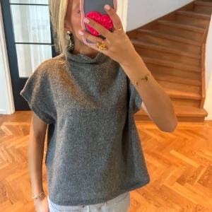 Grå stickad topp - grå stickad kortärmad topp från lindex som är slutsåld! använd en gång😊kragen är lite sydd för att vara lite längre ner men sitter som vanligt på bilden inga konstigheter, finns bilder om önskas!