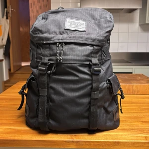 Svart ryggsäck från Burton - Stor svart ryggsäck från Burton med flera praktiska fack och justerbara remmar. Väskan har två stora ytterfickor med spännen, dragkedja upptill och invändigt fack för laptop eller surfplatta. Perfekt för dig som vill ha plats för allt och gillar stilren design. Enda defekten är på handtaget på bild 4, observera närbild så servärre ut än vad det är. Höjd 50 cm, bredd 40 cm, 30 L. Skriv vid funderingar❤️