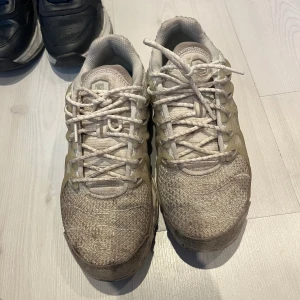 Nike vita sneakers med Crater-sula - Nike sneakers i vitt med transparenta detaljer och Crater-sula. Ovandelen har ett rutigt meshmönster och sidorna är förstärkta med syntetmaterial. Skorna har snörning och en chunky, prickig sula med återvunnet material.