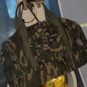 Camo weekend väska  - Jätte fin väska som jag köpte på second hand, jätte fin och får plats med mycket saker. Säljer pga kommer ej till användning ‼️dragkedjan har hoppat ut   ‼️
