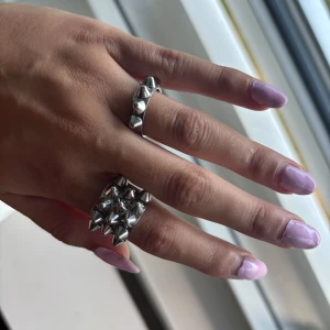 Två silvriga ringar med nitar - Jag säljer två trendiga ringar i rostfritt stål köpta från edblad. De säljs eftersom de är för stora. De är i storlek 16 mm/xs och är i silver. De är i nyskick och har använts ett fåtal gånger.  Skriv om du har någon funderinga eller vill ha fler bilder.💓 Pris kan diskuteras!  