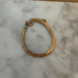 Guldigt kedjearmband - Armband i guldig färg med platt, tätt länkad kedja och enkel låsning. 