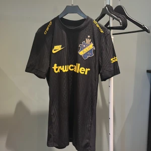 AIK matchtröja Nike Salétros S - AIK:s officiella matchtröja från Nike i svart med gula detaljer och klubbmärke på bröstet. Tröjan har korta ärmar, smal passform och är tillverkad i Dri-Fit ADV-material som andas. Salétros och nummer 7 på ryggen. Perfekt för dig som älskar AIK.  Använd två gånger ifk Norrköping hemma och Hammarby hemma