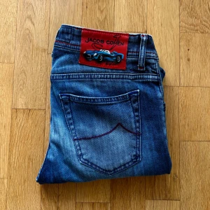 Jacob cohen jeans 622 - Limited editon jacob cohen jeans, endast 209 gjorda. Modellen på jeansen är 622, vilket är den snyggaste slim modellen. Jeansen har knappar med äkta silver, samt snygga röda detaljer. Byxorna är i nyskick och endast använda ett fåtal gånger, byxorna är lite upplagda hos eller skräddare. Detta är jeans nummer 83 av 209. Hör av er vid fler frågor!