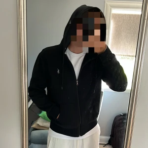 Svart zip från Ralph Lauren - Snygg svart hoodie från Ralph Lauren i storlek S. Tröjan har dragkedja, huva med snörning och två fickor framtill.  Skick: 9/10, Fraktar inom 1 dag.  Hör gärna av er vid frågor, Mvh.
