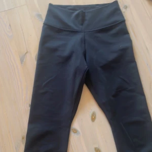 Svarta Nike leggings med hög midja - Svarta leggings från Nike med hög midja och klassisk vit swoosh-logga på benet. Tight passform och stretchigt material som passar perfekt till träning eller chill. Snygg och enkel design som funkar till det mesta. Aldrig använt, som nya! Skriv om ni har några funderingar!💞