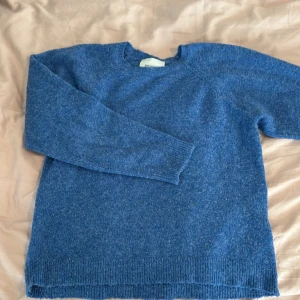 Blå stickad tröja från Sofie Schnoor - Mysig blå tunn stickad tröja från Sofie Schnoor. Tröjan har lång ärm och klassisk rund halsringning.