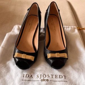 Svarta kilklackar med rosett från Ida Sjöstedt x Ellos - Snygga svarta pumps med kilklack och öppen tå från Ida Sjöstedt X Ellos