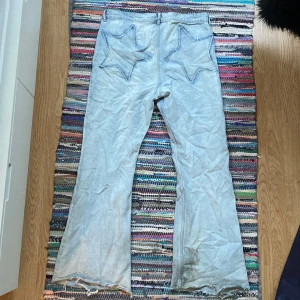 Y2K flared jeans - Asfeta flared jeans med stjärn motiv, väl använda. Strl 44, midja 42cm, innerben 72cm, ytterben 105cm