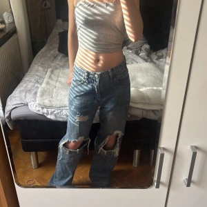 Blå jeans med hål på knäna - Säljer ett par blå baggy jeans med stora shål på båda knäna. Inget fel på dem, säljer för att det inte är min stil