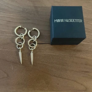 Guldörhängen från Maria Nilsdotter - Säljer ett par coola guldörhängen från Maria Nilsdotter. Det har tappat lite färg inne i ringarna men inget som syns, det går att lämna in på maria nilsdotter butiken så guldplaterar de om de för 500kr. Kommer i originalask. Jag kan även mötas upp 