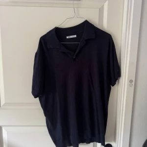 Svart pikétröja från Zara - En mörkblå piké från Zara i storlek M, ganska tunn och skönt material, perfekt till sommaren, nypris 400kr.