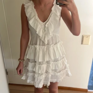 Vit volangklänning med v-ringning - Helt ny supersöt vit klänning från Hm med volanger och v-ringning. Perfekt till studenten och sommaren generellt! Storleken är xxs men är stor i storleken. Passar mig perfekt som i vanliga fall är storlek s. 