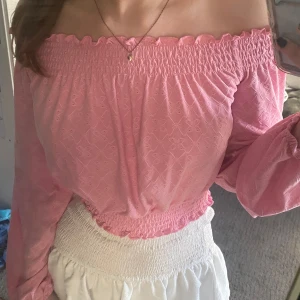 Rosa offshoulder blus - Säljer en söt rosa offshoulder blus med smock upptill och nertill. I storlek S men passar nog en XS med.