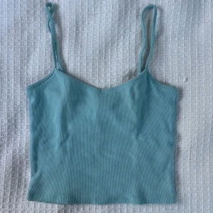 Ljusblå ribbad linnetopp från Monki - Säljer en ljusblå ribbad linnetopp från Monki med smala axelband och v-ringning. Perfekt för varma dagar och enkel att matcha med jeans eller kjol. Supermjuk och stretchig i materialet.