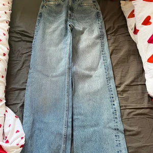 Blå wide leg jeans från Pull&Bear - Säljer ett par blå jeans från Pull&Bear med wide leg-passform och hög midja. Jeansen har slitna detaljer. 