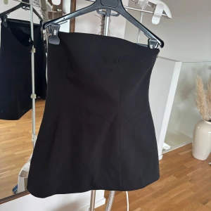 Svart top från MQ  - Säljer en svart, figurnära top från NA-KD. Topen har en enkel och stilren design utan synliga detaljer och är tillverkad i ett slätt material. Perfekt för dig som gillar minimalistisk stil. Nypris 700kr använd vid ett tillfälle 