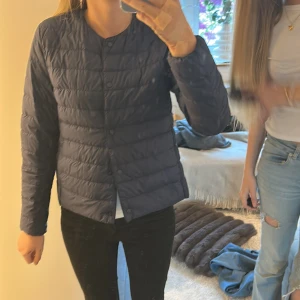 Mörkblå lättviktsdunjacka från Uniqlo - Säljer en mörkblå, tunn och smidig dunjacka från Uniqlo i modellen Ultra Light Down. Jackan har lång ärm, knäppning framtill och är quiltad för extra värme utan att bli klumpig. Perfekt för lager-på-lager under kyliga dagar.