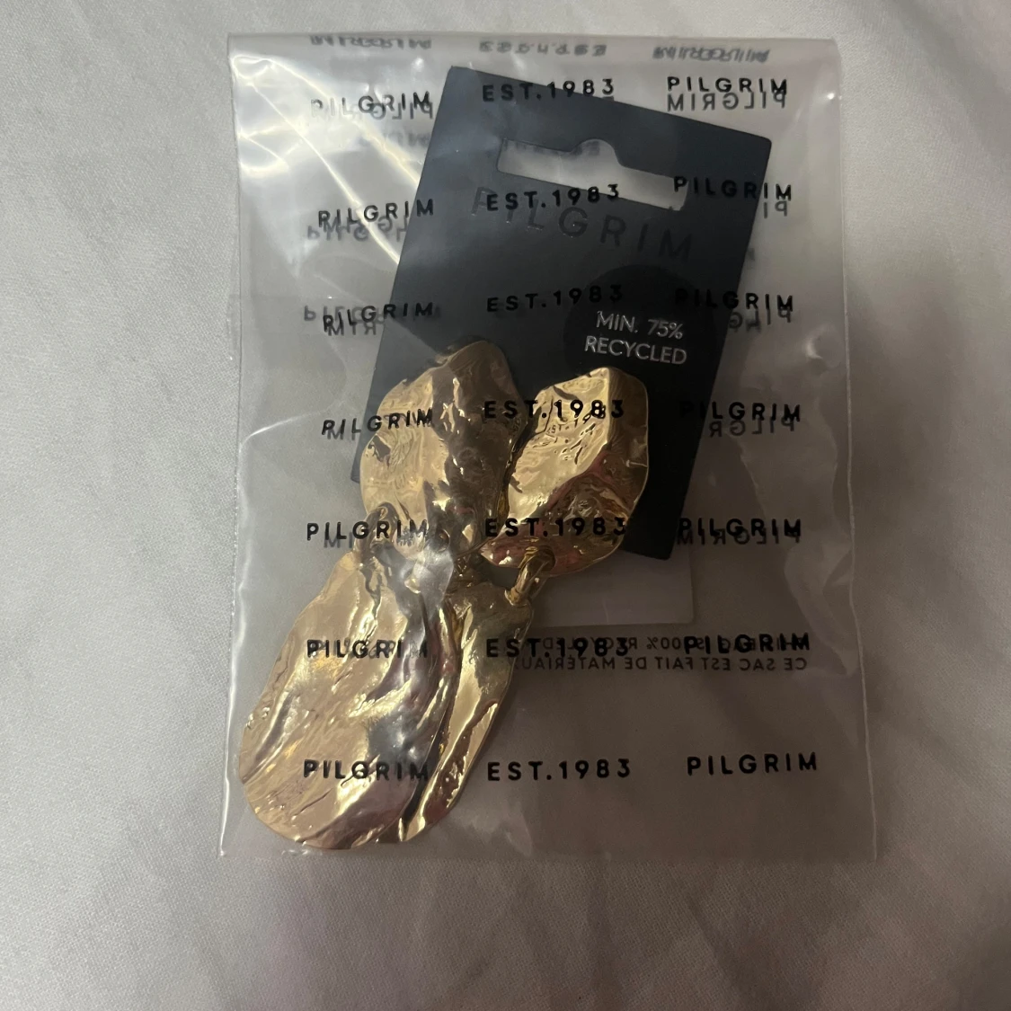 Guldiga statement örhängen från Pilgrim