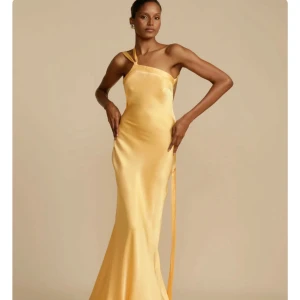 Gul långklänning med oneshoulder och öppen rygg - Suupersnygg satinklänning perfekt till bal! Säljer pga lite för stor för mig (är 158cm, vanligtvis xs). Helt oanvänd💕orginalpris: 740kr