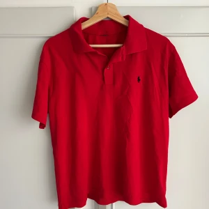 Röd pikétröja från Ralph Lauren - Säljer en klassisk röd pikétröja från Ralph Lauren,Snygg och perfekt nu till sommaren.Strorlek M, lappen är borta men den är mellan S och M passar båda
