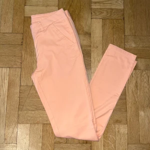 Aprikosfärgade chinos - Ett par söta aprikosfärgade chinos från VILA med normal passform och raka ben. Byxorna är i storlek S och har fickor fram och bak, samt är tillverkade i ett mjukt bomullsmaterial! 🤍
