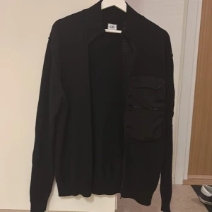 CP company cardigan - Säljer denna stickade cardigan från CP, mycket bra skick använd ytterst lite. Den sitter lite större i storleken. Gäälet fräsch