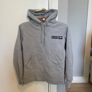 Björn Borg Hoodie - Säljer en klassisk grå hoodie från björn Borg. I storlek S, inga tydlig bevis på användning förutom en jätte liten fläck (se bild 3, men går  bort med fläckborttagning) 7/10 skick. 