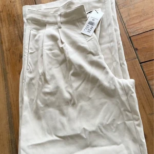 Byxa  - Beige vidare byxa 