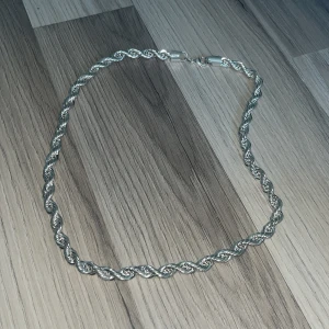 Silver tvinnat halsband - Säljer ett snyggt halsband i silver med tvinnad kedja. Perfekt för dig som gillar stilrena accessoarer med lite extra detalj. Lås i samma färg som kedjan. 8mm (pris kan diskuteras) köpte för 3500