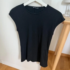 Svart glittrig topp från zara - En stilren svart glittrig topp från Zara i storlek S. 