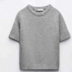 Stickad t-shirt - Mysig grå stickad tröja från Zara med korta ärmar och rund halsringning. Perfekt för lager-på-lager och enkel att matcha med olika outfits. Klassisk och stilren design. Lite knopprig