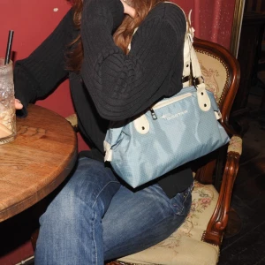 Blå och beige axelväska  - Snygg blå axelväska från Sigestar med beigea detaljer och justerbar axelrem. Väskan har ett rutigt mönster och en praktisk dragkedja framtill. Perfekt för att bära dina dagliga nödvändigheter med stil.💜