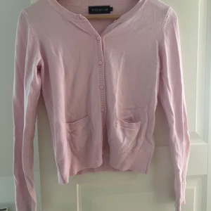 Rosa kofta från Stockh LM - Säljer en söt rosa kofta från Stockh LM i storlek XS. Koftan har långa ärmar och knäppning framtill med små knappar. Den har två praktiska fickor fram och ribbade kanter vid ärmslut och nederkant. Perfekt för en mysig dag!